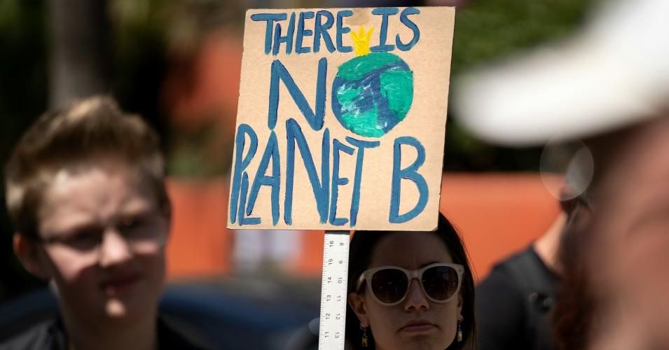A protester is seen during a climate change demonstration holding a placard that says, 'There Is No Planet B.' 