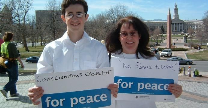Two people hold "for peace" signs