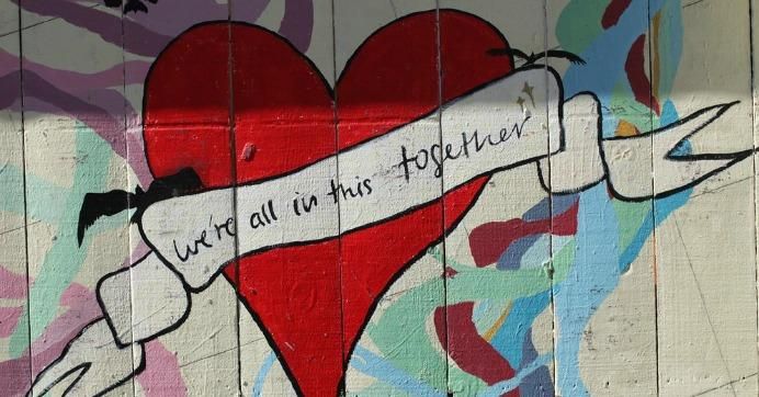  Grafitti of heart with message "We are all in this together."