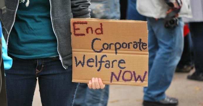 Sign reads: End corporate welfare now