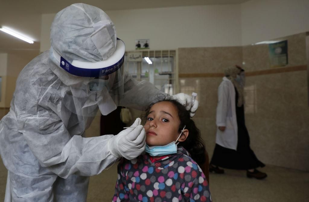 A Palestinian paramedic takes a nasal swab to test for the coronavirus, at the Ministry of Health Sabha Al Harazeen clinic, in Al Shejaeiya neighborhood, in the east of Gaza City, 22 March 2021. (Photo by Majdi Fathi/NurPhoto via Getty Images)