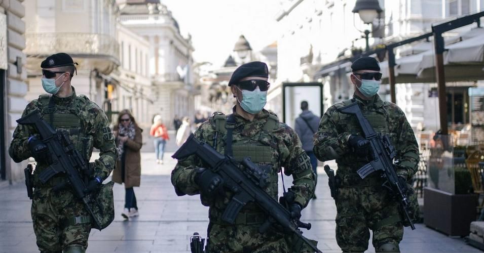 Serbian army soldiers wearing gloves and face masks as preventive measures against COVID-19 (novel Coronavirus), patrol on one of the main pedestrian streets in Belgrade on March 17, 2020. (Photo: Vladimir Zivojinovic / AFP via Getty Images)