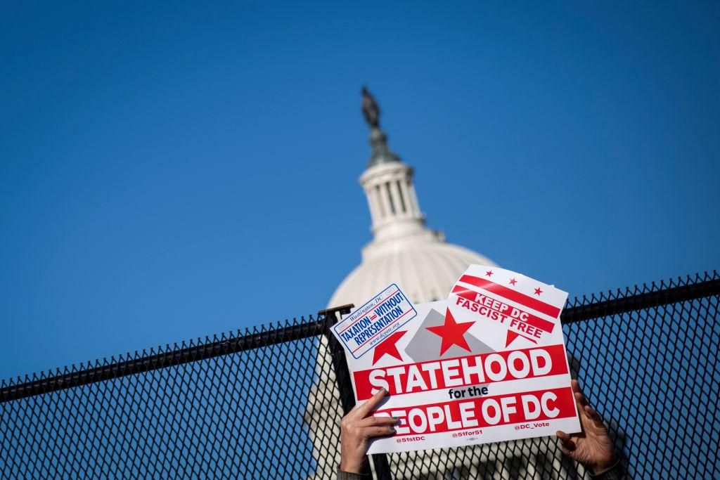 A demonstrator holds up a sign as DC statehood activists gather in front of the Capitol to show support ahead of the House Oversight and Reform Committee hearing on the "Washington, D.C. Admission Act", making DC the 51st state in Washington on Monday, March 22, 2021. (Photo by Caroline Brehman/CQ-Roll Call, Inc via Getty Images)