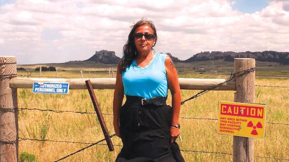 Debra White Plume stands at Cameco Corp. uranium mine field 30 miles south of Pine Ridge Indian Reservation, in Nebraska. Pollution from the site, which is located at the base of the sacred Crow Butte and named after it, inspired her film "Crying Earth Rise Up." (Photo: Courtesy Crying Earth Rise Up)