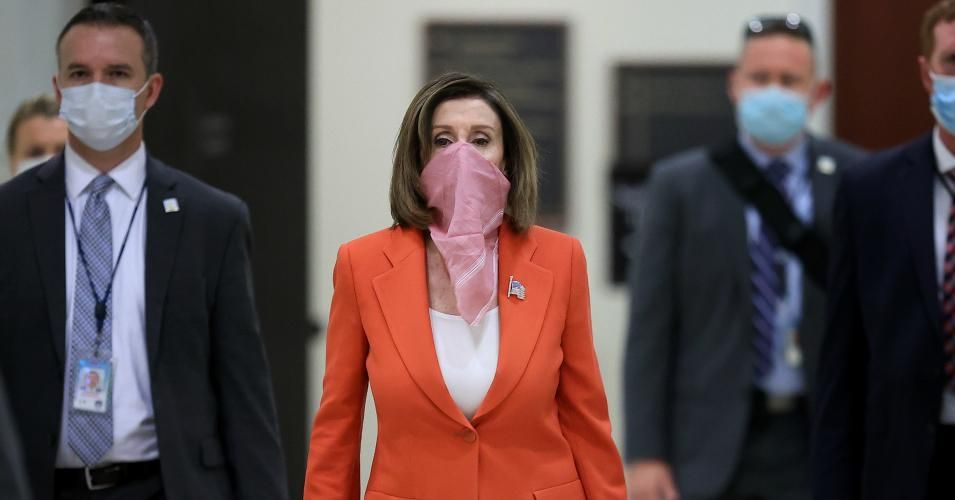 Wearing a scarf over her mouth and nose, Speaker of the House Nancy Pelosi (D-CA) is surrounded by security and staff as she arrives for her weekly news conference during the novel coronavirus pandemic at the U.S. Capitol April 24, 2020 in Washington, DC. (Photo: Chip Somodevilla/Getty Images)