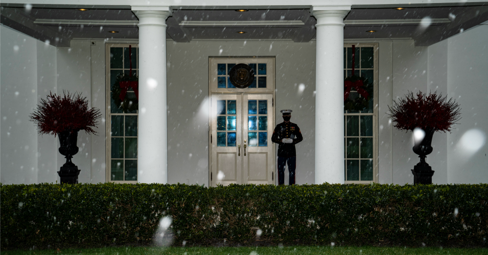 A Marine stands guard outside the West Wing, signifying the president is in the Oval Office, as snow begins to fall at the White House on Wednesday, December 16, 2020 in Washington, D.C.