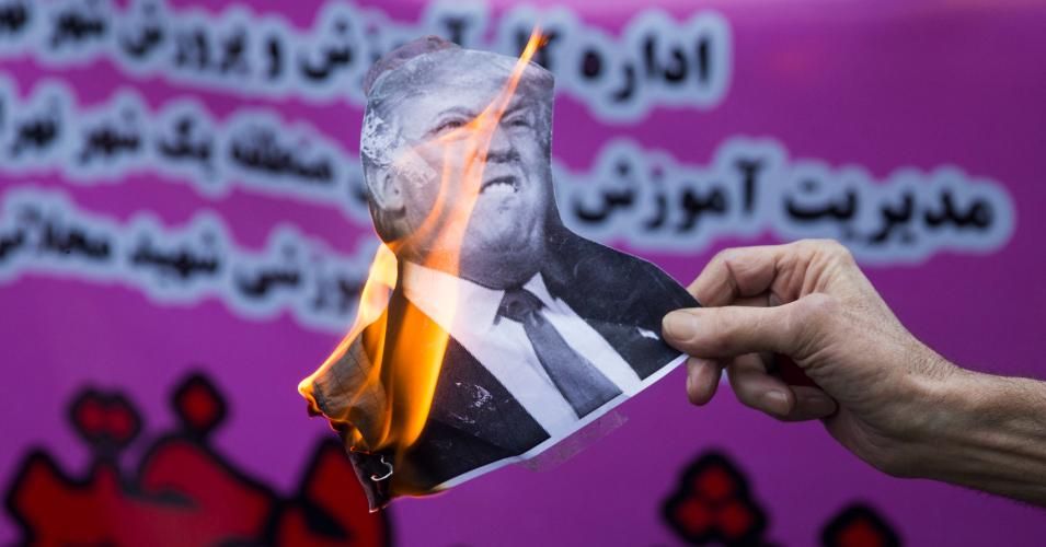 On the eve of renewed sanctions by Washington, an Iranian protester holds a burning picture of President Donald Trump outside the former US embassy in the Iranian capital Tehran on November 4, 2018. (Photo: Majid Saeedi/Getty Images)