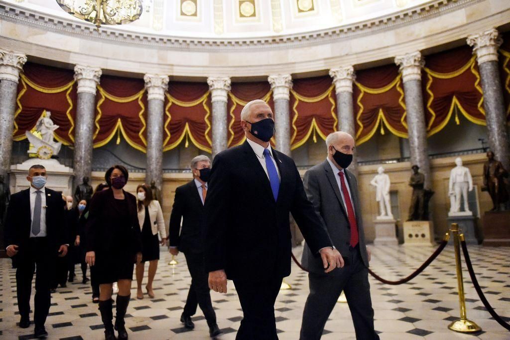 US Vice President Mike Pence (C) walks back from the House Chamber followed by a Senate procession carrying boxes of Electoral Votes, at the Capitol, on January 7, 2021 in Washington, DC. (Photo by OLIVIER DOULIERY/AFP via Getty Images)