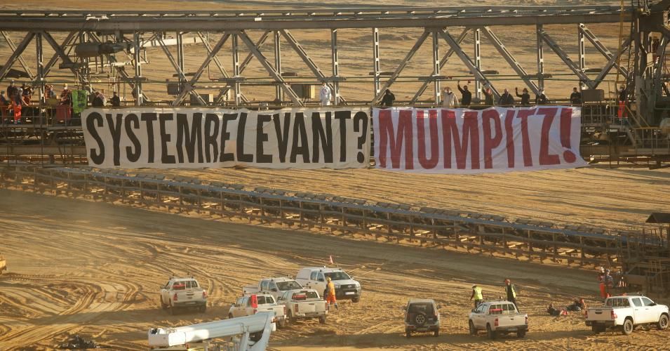 Activists from "Ende Gelände" have invaded the Garzweiler open-cast mine and occupied a lignite excavator. A banner with the inscription "System relevant? Mumpitz!" was attached to the excavator. The activists are behind it. (Photo: David Young/picture alliance via Getty Images)