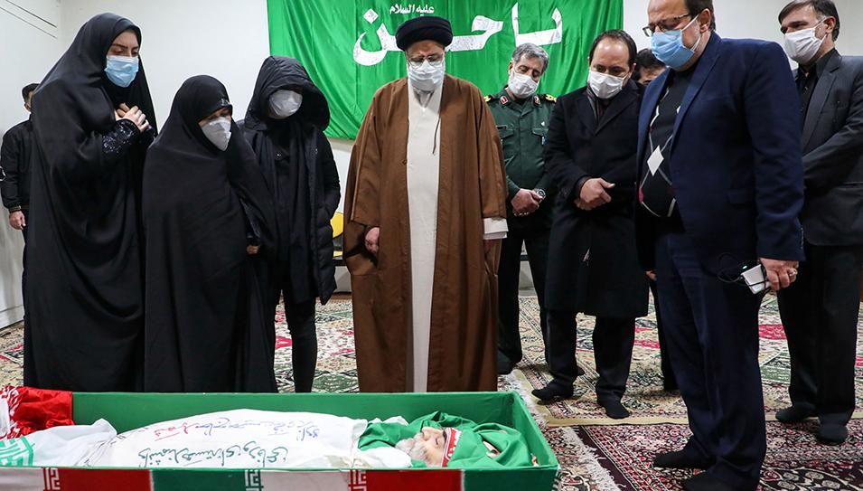Iran's Judiciary Chief Ayatollah Ebrahim Raisi (C) pays respects to the body of slain scientist Mohsen Fakhrizadeh among his family, in the capital Tehran on November 28, 2020