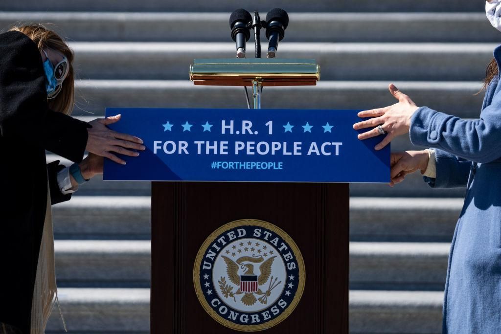 Staffers place a sign on a podium in preparation for a news conference with House Democrats regarding H.R. 1, the For the People Act, on Capitol Hill on Wednesday, March 3, 2021 in Washington, DC. (Kent Nishimura / Los Angeles Times via Getty Images)