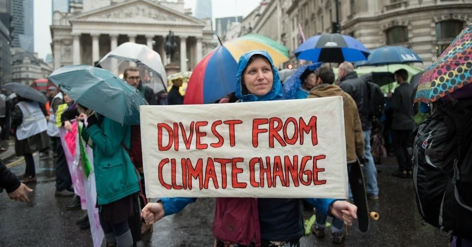 An Extinction Rebellion protester holds up a placard saying "Divest from climate change" on October 14, 2019 in London, England.