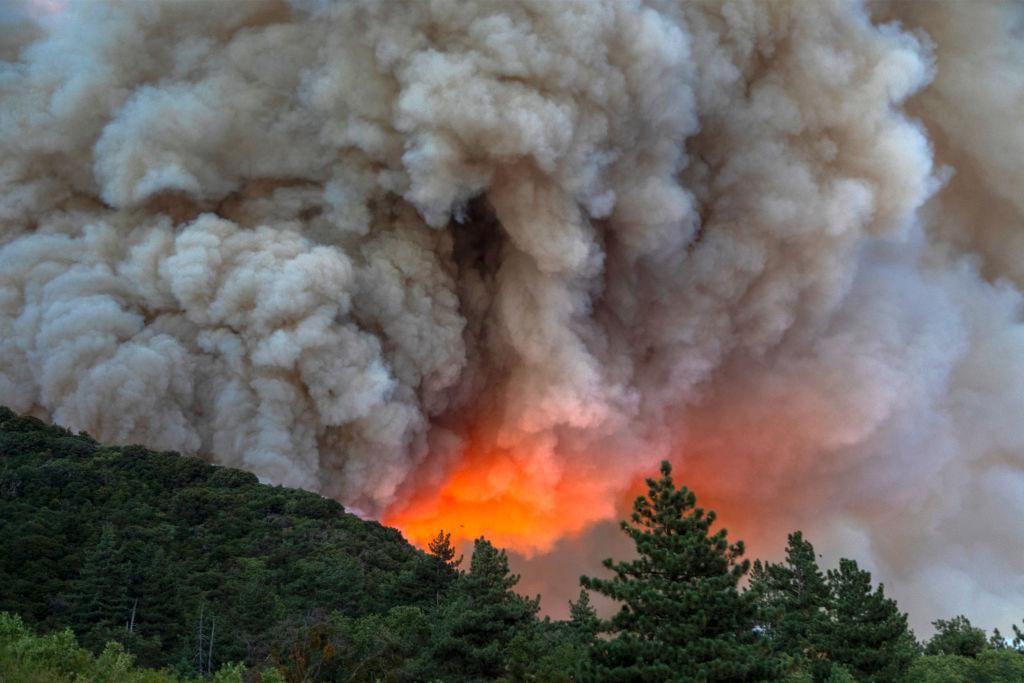 Flames and heavy smoke approach on a western front of the Apple Fire, consuming brush and forest at a high rate of speed during an excessive heat warning on August 1, 2020 in Cherry Valley, California. The fire began shortly before 5 p.m. the previous evening, threatening a large number of homes overnight and forcing thousands to flee before exploding to 12,000 acres this afternoon, mostly climbing the steep wilderness slopes of the San Bernardino Mountains. (Photo by David McNew/Getty Images)