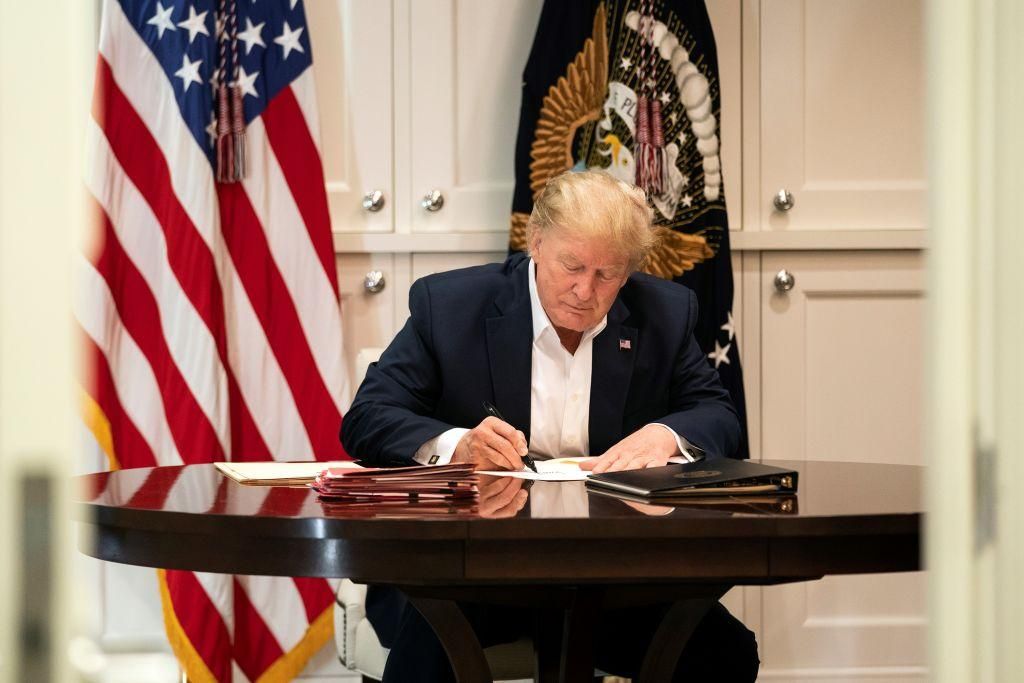 In this handout provided by The White House, President Donald J. Trump works in the Presidential Suite at Walter Reed National Military Medical Center after testing positive for COVID-19 on October 3, 2020 in Bethesda, Maryland. President Trump’s medical team says the President’s oxygen levels dropped and he took a steroid treatment of dexamethasone. (Photo by Joyce N. Boghosian/The White House via Getty Images)