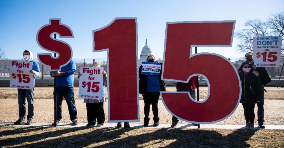 Activists with Our Revolution hold $15 minimum wage signs outside the Capitol complex on Thursday, February 25, 2021.