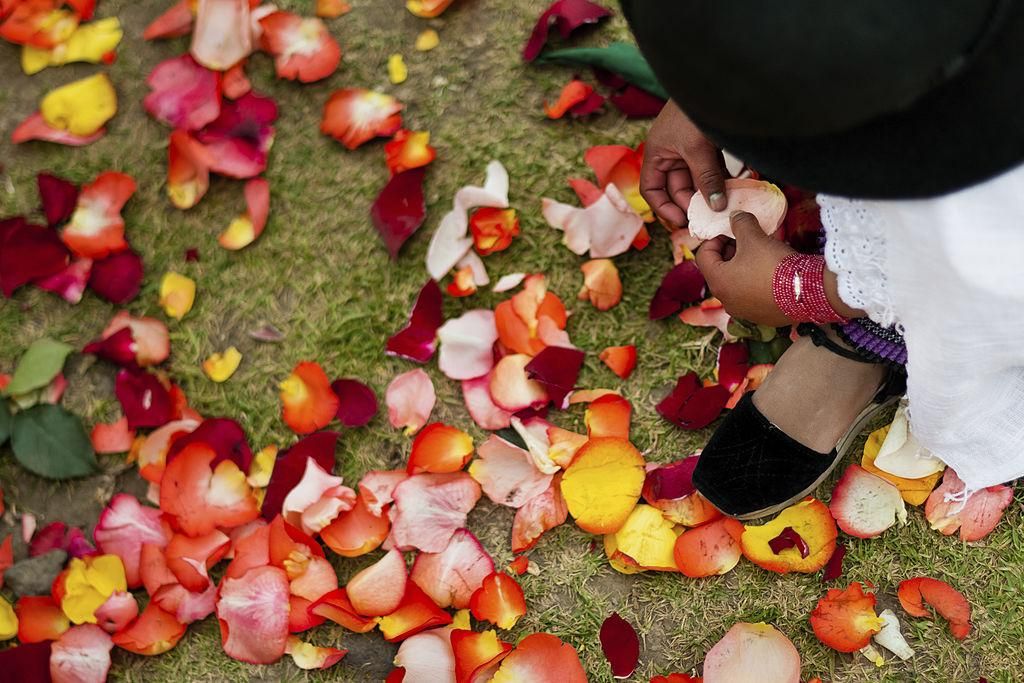 A young girl plays with colorful rose petals during the Inti Raymi celebration in the village of Pesillo, Ecuador. The highland Indians, wearing beautiful costumes, dance, drink and sing with no rest. Colorful processions in honor of the God Inti (Sun) pass through the mountain villages giving thanks for the harvest and expressing their deep relation to the Mother Earth (Pachamama). (Photo by Jan Sochor/Latincontent/Getty Images)