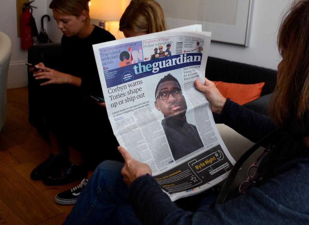 A tourist reads a copy of The Guardian newspaper in the lobby of a hotel in London, England. (Photo by Robert Alexander/Getty Images)