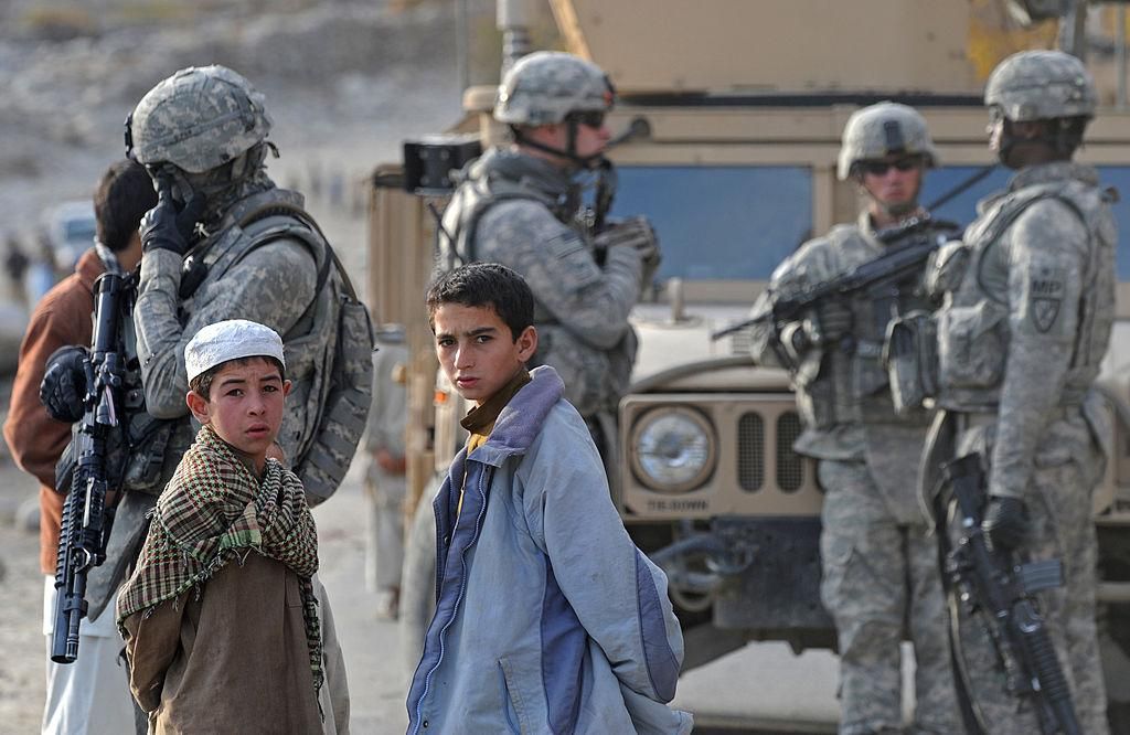 Afghan children look on as US soldiers from 2-77 Field Artillery MPs 359th Steel Warriors patrol in Nuristan Province on December 18, 2009. US President Barack Obama vowed December 10 that Afghanistan would not become a "permanent protectorate" of the United States as he defended his decision to begin withdrawing US forces in July 2011.(Photo: TAUSEEF MUSTAFA/AFP via Getty Images)