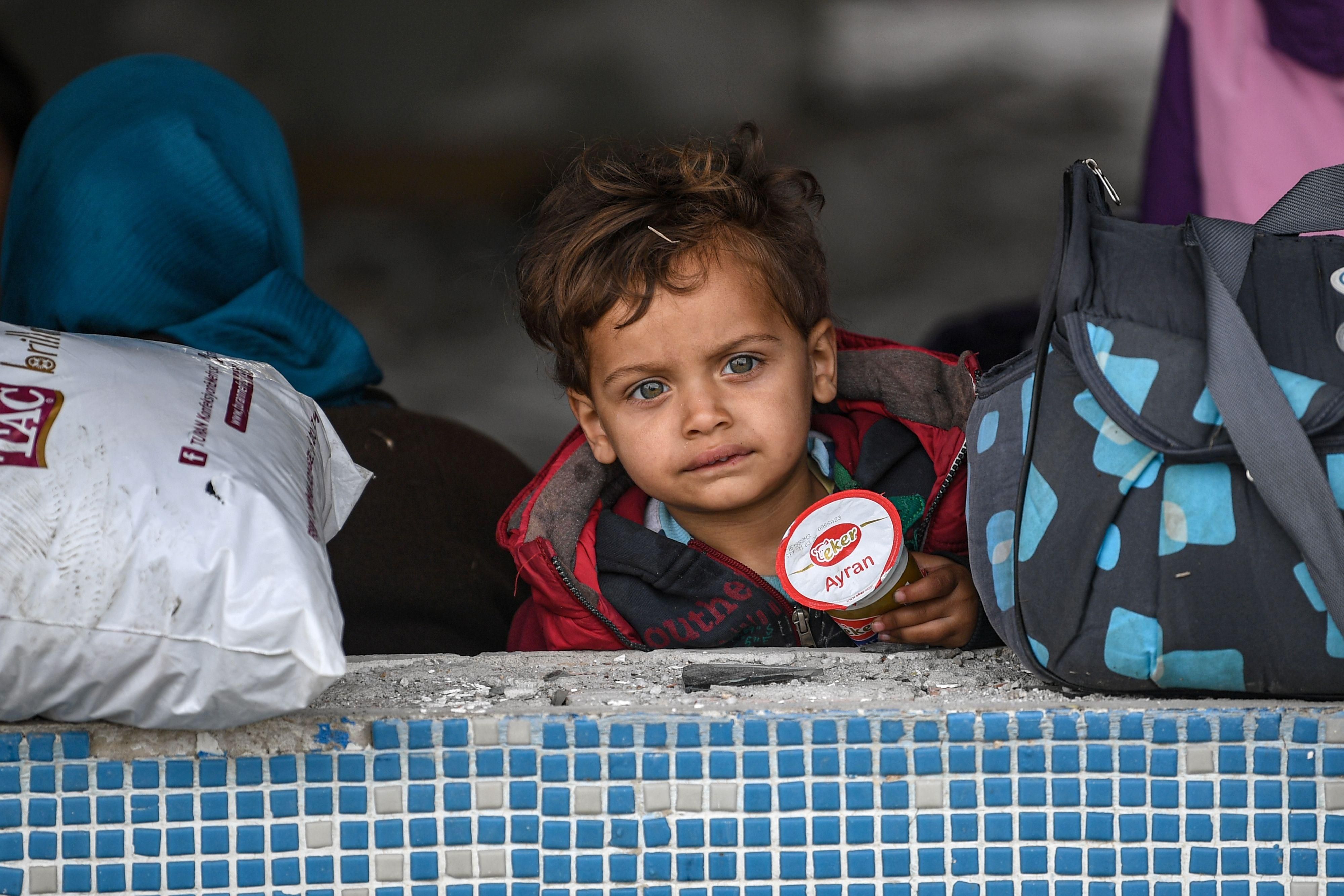 A child looks on as migrants take shelter inside a abandoned building as they gather in city center waiting to resume their efforts to enter Europe in Edirne, northwestern Turkey on March 5, 2020. The EU has scrambled to respond to the surge of migrants at the Greek border, where authorities say some 24,000 were stopped from entering between February 29 - March 2, 2020. (Photo: OZAN KOSE/AFP via Getty Images)