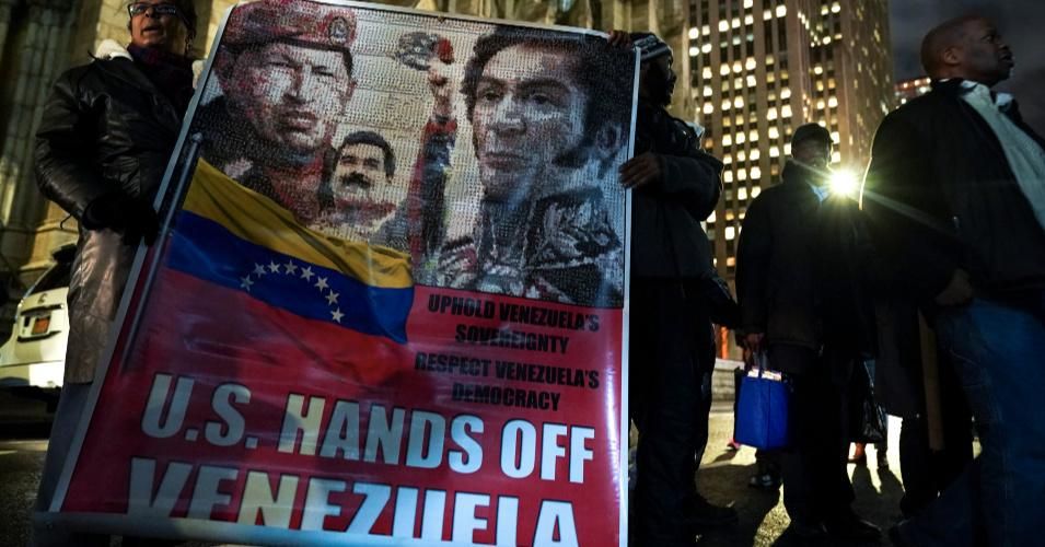 Protestors rally in support of Venezuelan President Nicolas Maduro as they hold a banner featuring the late former president of Venezuela Hugo Chavez, the current president of Venezuela Nicolas Maduro and 19th century Venezuelan military and political leader Simon Bolivar, outside the Venezuelan Consulate in Midtown Manhattan, January 24, 2019 in New York City. The Trump administration, along with several other governments in the region, has recognized opposition leader Juan Guaido as the rightful head of s