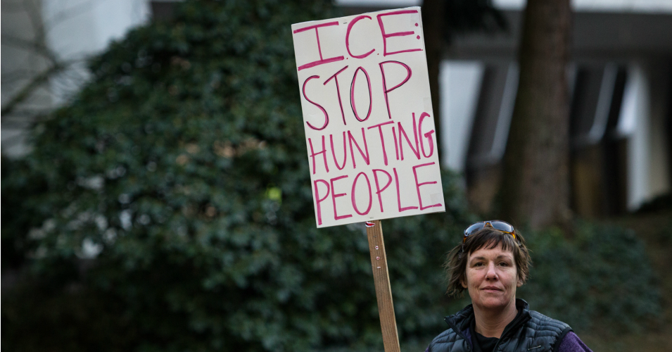 A protest sign against ICE raids at an immigration rally