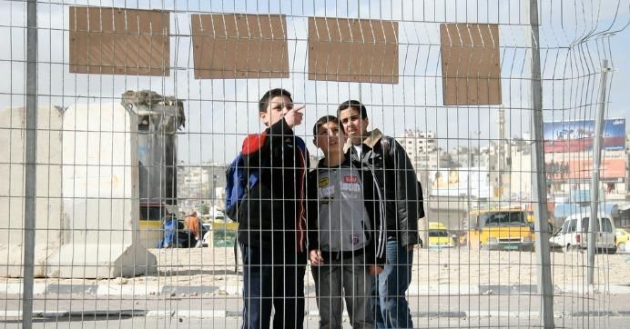 Boys stand near a checkpoint in the occupied West Bank. 