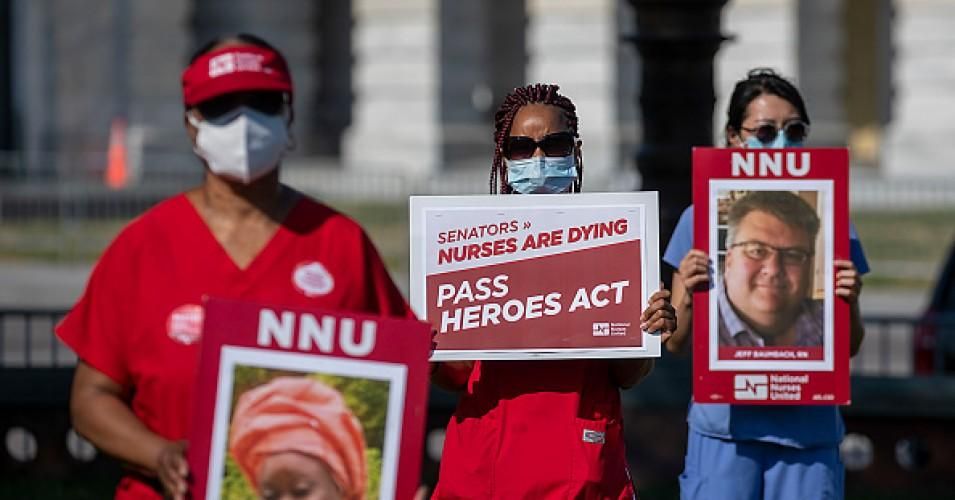 Nurses hold signs at a Vigil for Nurses Who've Died From Covid-19 at the U.S. Capital on July 21, 2020 in Washington, D.C.