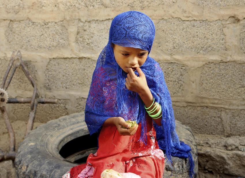A girl eats boiled leaves from a local vine to stave off starvation in the district of Aslam, Hajjah, Yemen. (Photo: Hammadi Issa / AP)