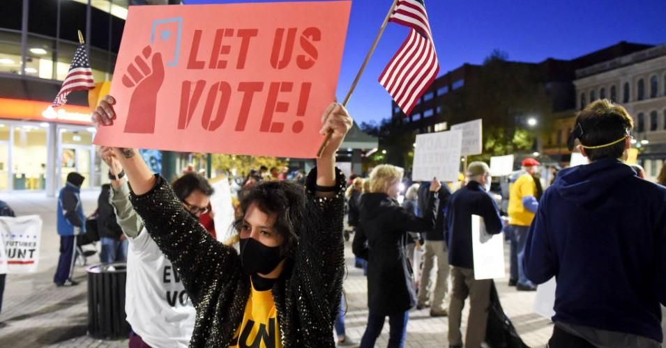 A rally participant holds a sign that reads "Let Us Vote!" in Reading, Pennsylvania on November 4, 2020.