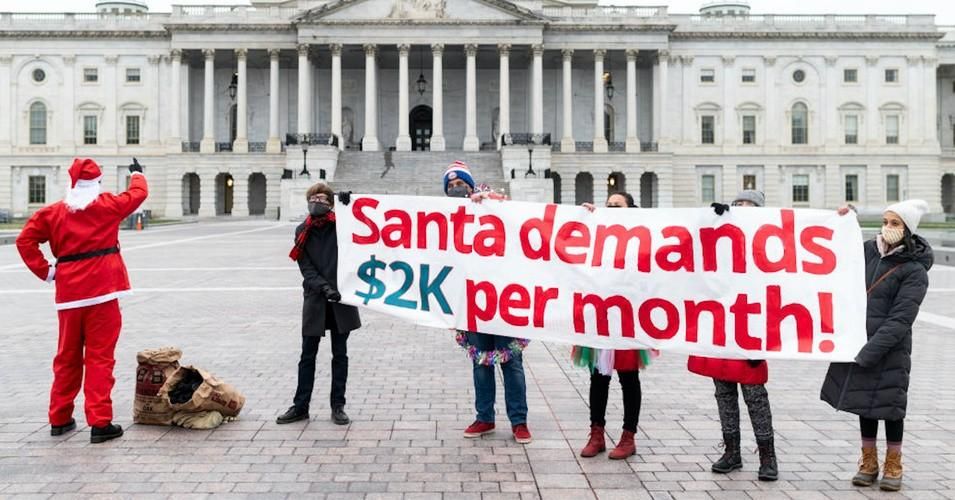 Members of Metro D.C. Socialists hold a Christmas morning protest asking "Santa Claus" to deliver coal to Congress, while demanding a $2,000 per month check, at the U.S. Capitol on Friday, Dec. 25, 2020.