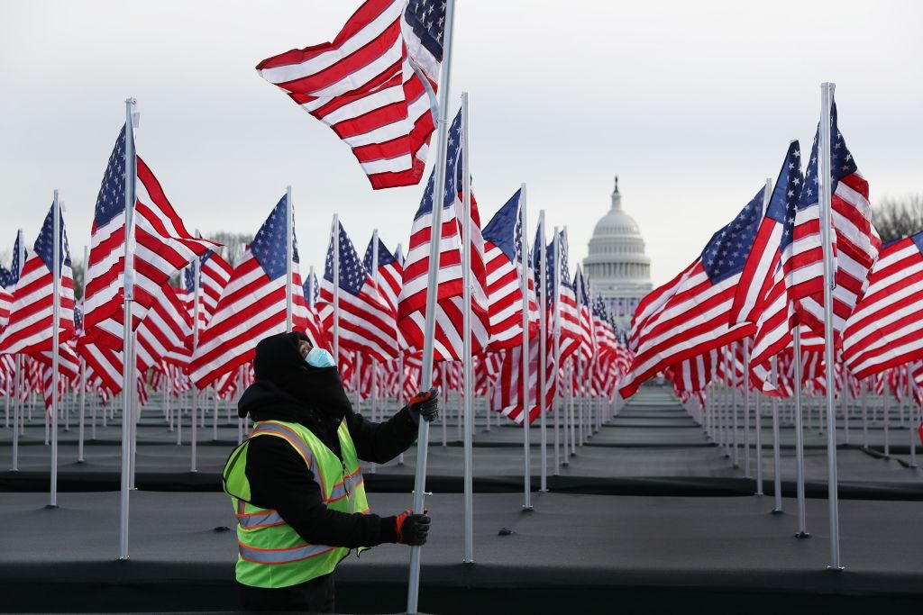 Aaron Haines helps place American flags on the National Mall as the U.S Capitol Building is prepared for the inaugural ceremonies for President-elect Joe Biden on January 18, 2021 in Washington, DC. The approximately 191,500 U.S. flags will cover part of the National Mall and will represent the American people who are unable to travel to Washington, DC for the inauguration. (Photo by Joe Raedle/Getty Images)