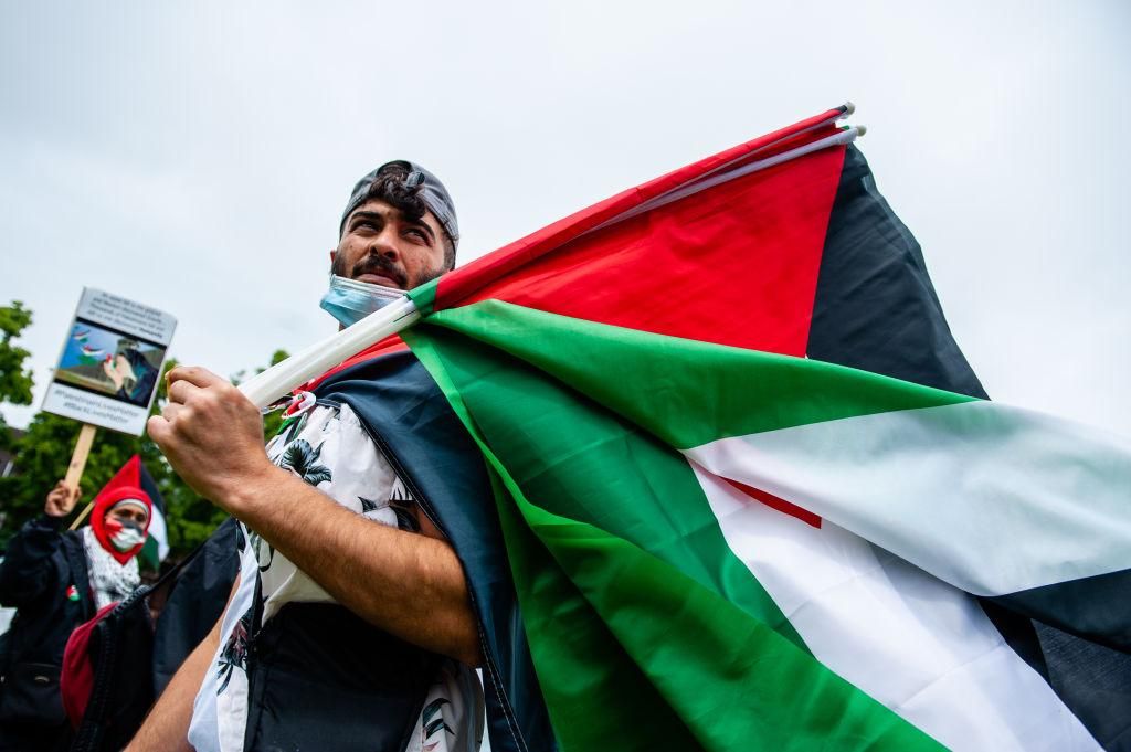 A Palestinian man is giving Palestinian flags to the people, during the demonstration in solidarity with Palestine, at the Museumplein in Amsterdam, Netherlands on June 14th, 2020. (Photo by Romy Arroyo Fernandez/NurPhoto via Getty Images)