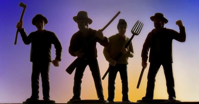 An angry group of four people with one holding a pitchfork
