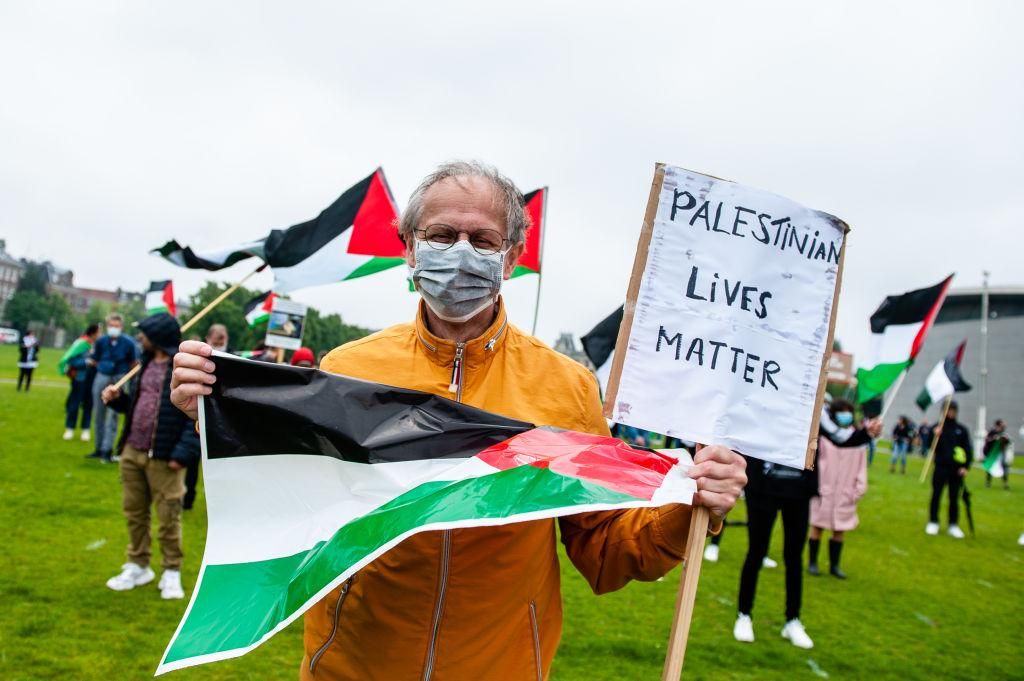 A man holding a Palestinian flag and a placard that says, Palestinian Lives Matter, during a demonstration in Amsterdam. Hundreds of people gathered at the Museumplein in support of Palestine and against Israels plans to annex parts of the West Bank in Gaza on June 14th. (Photo by Ana Fernandez/SOPA Images/LightRocket via Getty Images)
