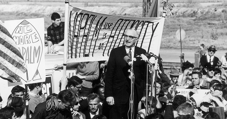 U.S. Senator Wayne Morse (D-Or.) at a peace rally during the U.S. war in Vietnam stands in front of a banner that reads "Napalm use if an atrocity." (Photo: Wayne Morse Center for Law and Politics / University of Oregon)