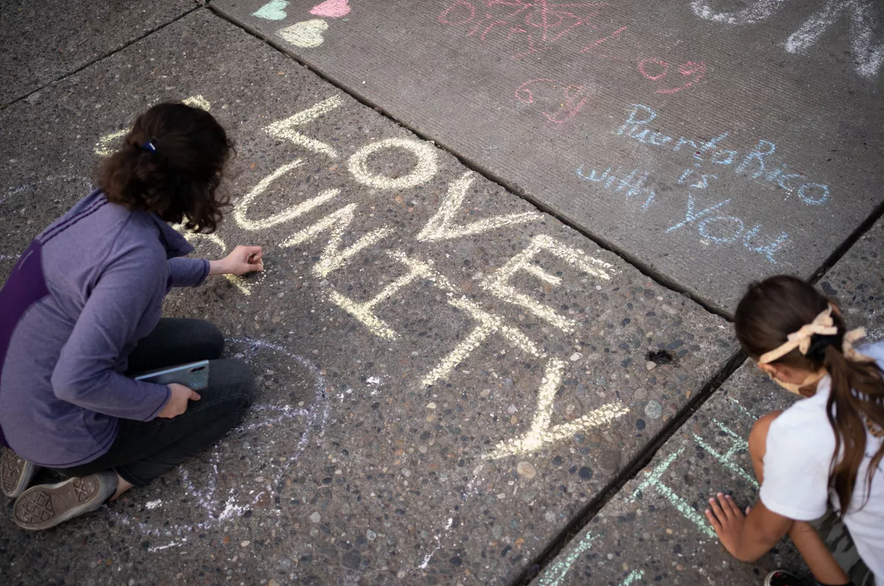 People draw messages with chalk in a Seattle intersection. (Photo: David Ryder/Getty Images)