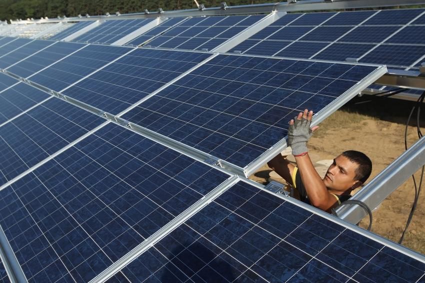 A worker installs solar panels at the Solarpark Eggersdorf solar park on September 4, 2012 near Muencheberg, Germany. (Photo by Sean Gallup/Getty Images)
