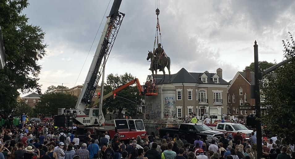 A crown of onlookers watch as the Stonewall Jackson Monument in Richmond Virginia is being removed by a crane on July 1, 2020 in Richmond, Virginia. Mayor Levar Stoney ordered the removal of all Confederate statues from city land. 