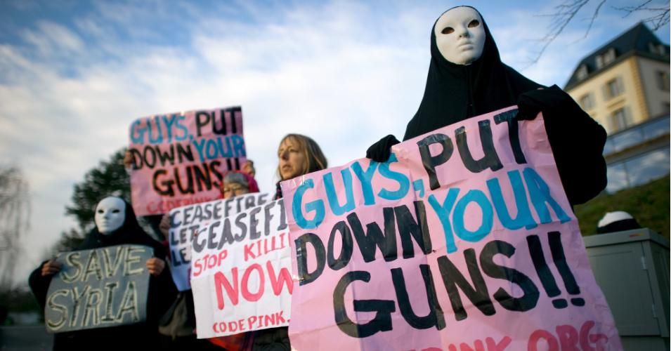 Activists with "CodePink women for peace" hold a banner reading "Guys Put Down Your Guns !!" on January 24, 2014 at the entrance of the United Nations Office in Geneva. (Photo: CodePink/flickr)