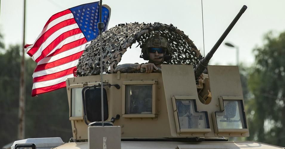 A US soldier stands in an armoured personnel carrier as the US forces pull out of their base in the Northern Syrian town of Tal Tamr, on October 20, 2019. - US forces withdrew from a key base in northern Syria today, a monitor said, two days before the end of a US-brokered truce to stem a Turkish attack on Kurdish forces in the region. (Photo: Delil Souleiman/AFP via Getty Images)