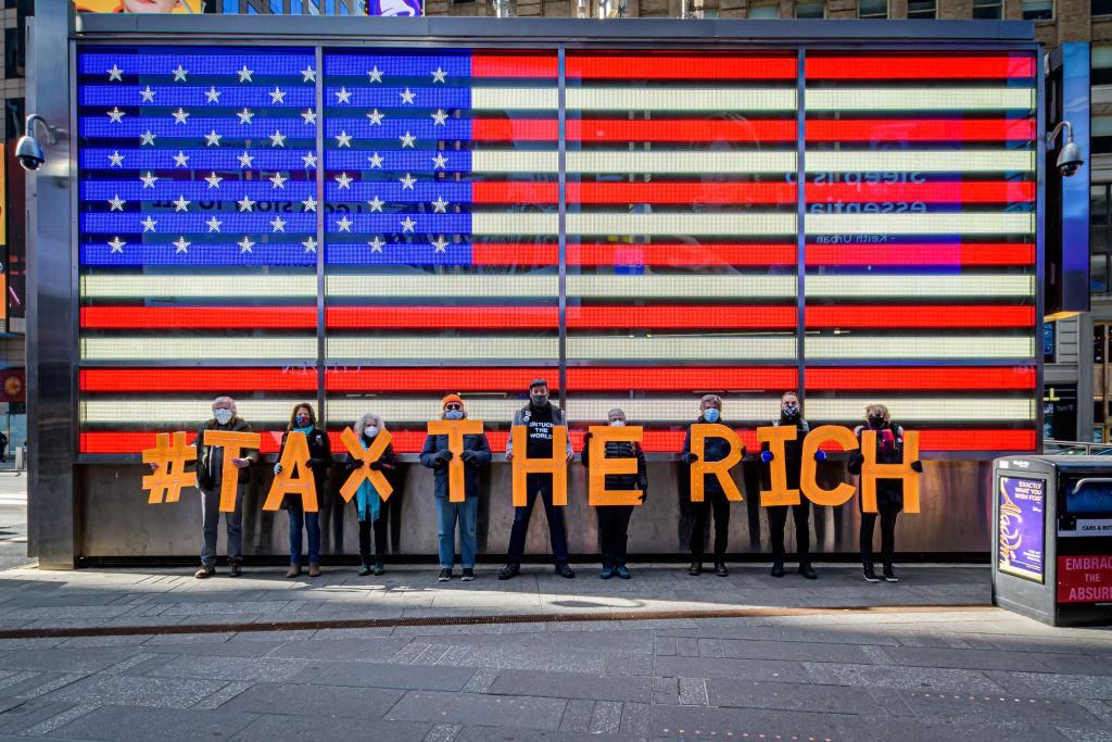 Participants seen spelling out #TaxTheRich at Times Square. As 6 bills will soon be introduced in the legislature to tax wealthy corporations and individuals who haven't been paying their fair share, a coalition of Activists gathered around New York City landmarks to call for the Equitable Taxation of Corporations, demanding legislators to pass the Financial Transaction Tax to generate around 9 billion dollars needed for COVID Recovery, and Essential Services. (Photo by Erik McGregor/LightRocket via Getty I