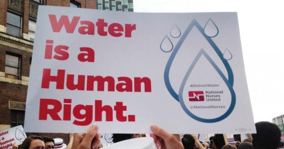 A demonstrator holds a sign during a Detroit water shutoffs rally in 2014. 