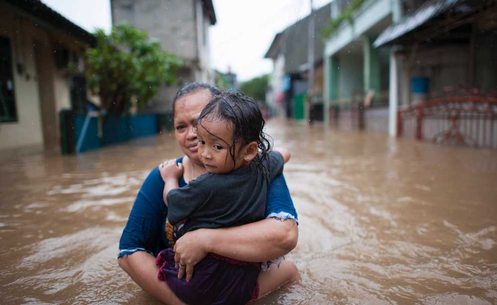Woman and child in flood in Indonesia. (Photo: World Meteorological Organisation, Flickr/Climate Visuals)