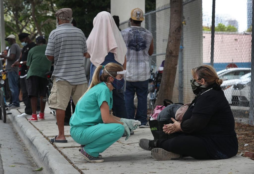 Dr. Natalia Echeverri, (L) asks Karen Rosales if she is in need of a COVID-19 test or anything else as she checks on the homeless on April 17, 2020 in Miami, Florida. (Photo: Joe Raedle/Getty Images)