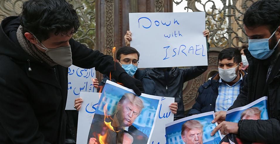 Students of Iran's Basij paramilitary force burn posters depicting US President Donald Trump, during a rally in front of the foreign ministry in Tehran, on November 28, 2020, to protest the killing of prominent nuclear scientist Mohsen Fakhrizadeh a day earlier near the capital. - Iran's President Hassan Rouhani accused arch-foe Israel of acting as a "mercenary" for the US and seeking to create chaos, blaming it for the assassination of a top Iranian nuclear scientist