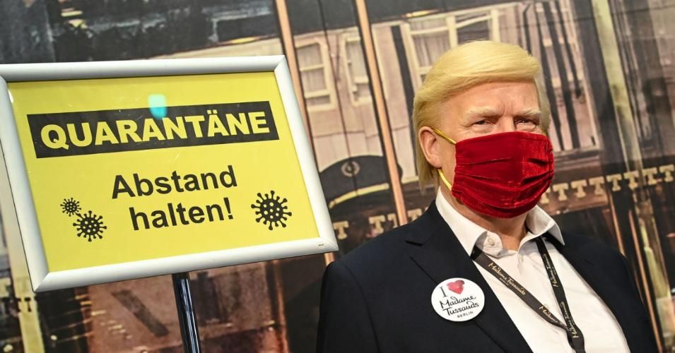 The wax figure of US President Donald Trump stands behind a barrier and signs saying "Keep your distance from quarantine" at Madame Tussauds Berlin. Photo: Britta Pedersen/dpa-Zentralbild/ZB (Photo: Britta Pedersen/picture alliance via Getty Images)