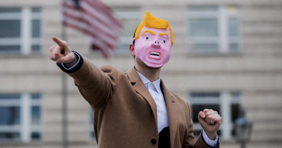 A man wearing a mask meant to represent U.S. President Donald Trump with a pig's nose dances in front of the U.S. Embassy for a video of a satirical project by a design student. Photo: Christoph Soeder/dpa (Photo by Christoph Soeder/picture alliance via Getty Images)