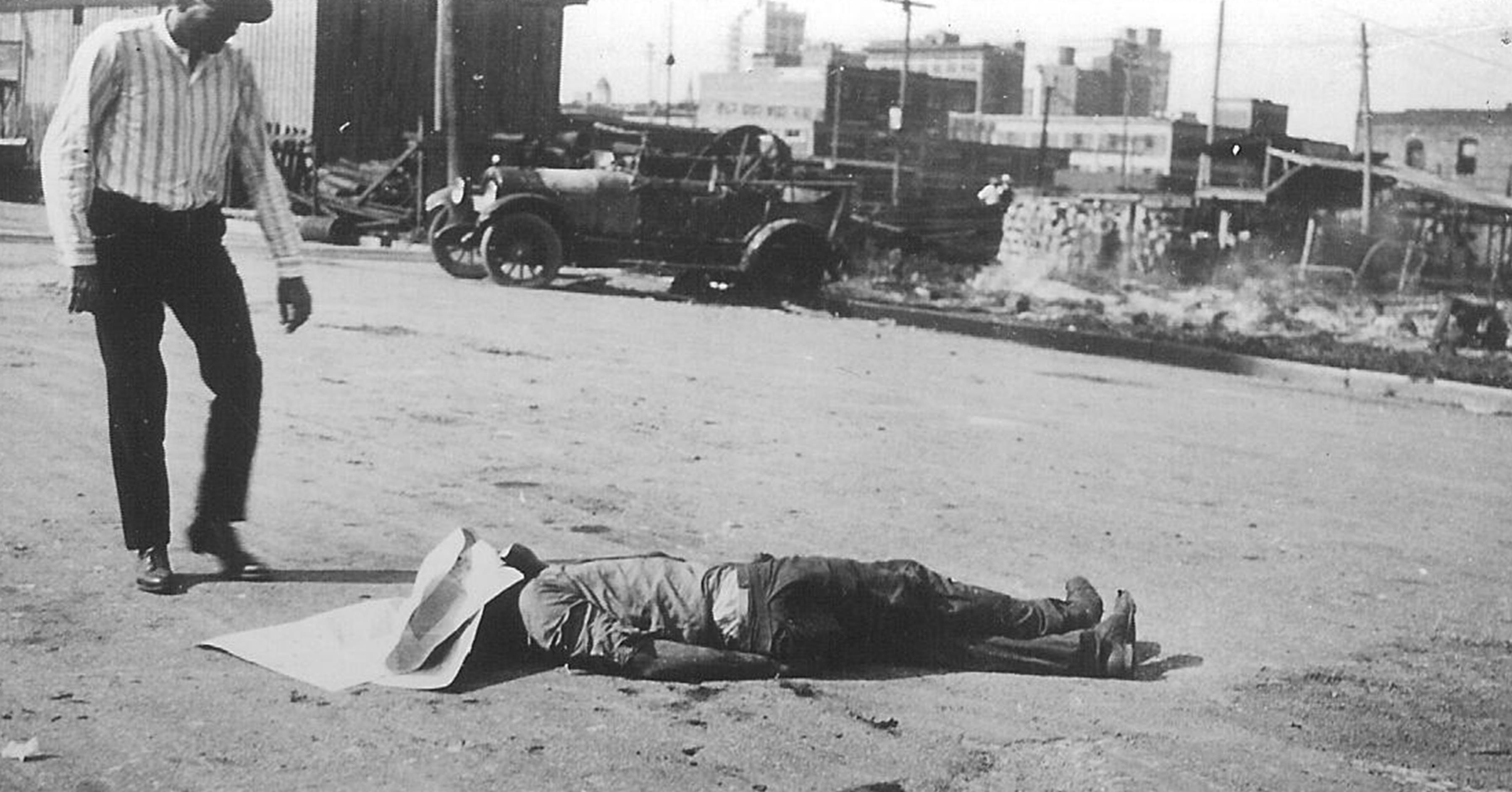 The body of an unidentified black victim of the Tulsa Race Massacre lies in the street as a white man stands over him, Tulsa, Oklahoma, June 1, 1921. (Photo: Greenwood Cultural Center/Getty Images)