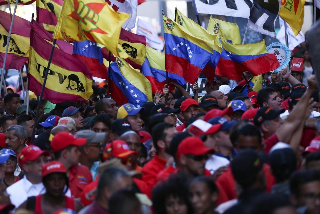 Government supporters are waving Venezuelan flags in a protest against the announcement of new US sanctions against the Venezuelan airline Conviasa.(Photo by Pedro Rances Mattey/picture alliance via Getty Images)