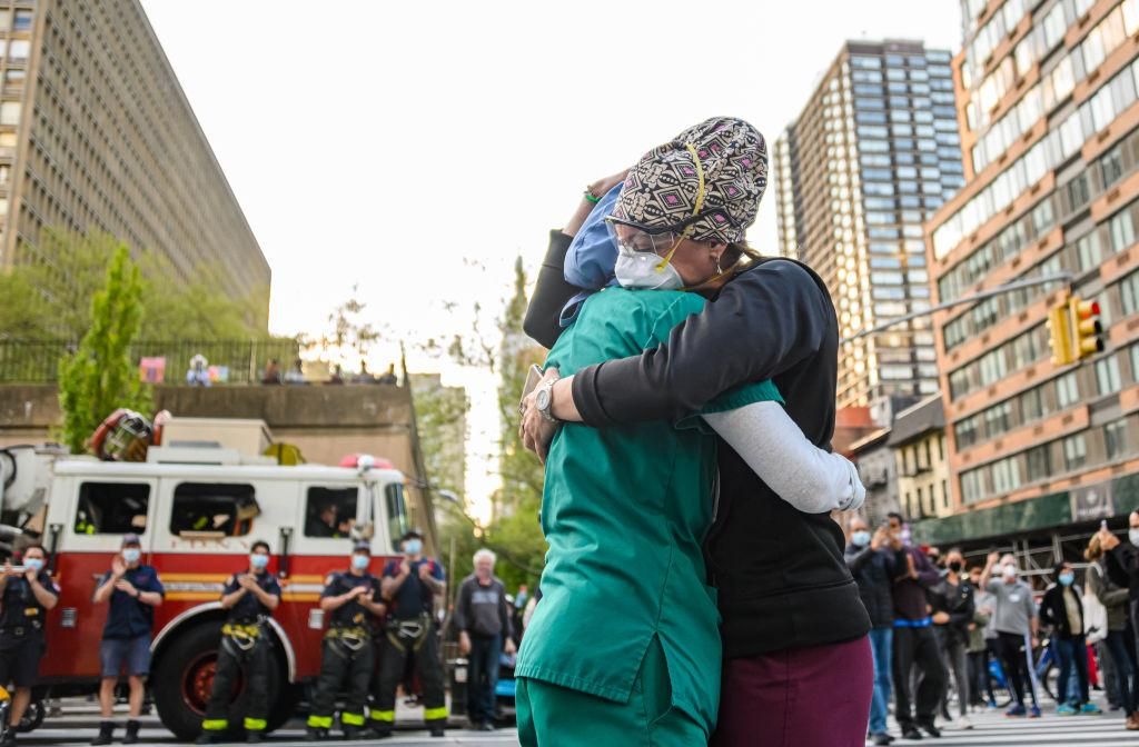Medical workers hug outside NYU Langone Health hospital as people applaud to show their gratitude to medical staff and essential workers during the coronavirus pandemic on May 7, 2020 in New York City. COVID-19 has spread to most countries around the world, claiming over 270,000 lives with over 3.9 million infections reported. (Photo by Noam Galai/Getty Images)
